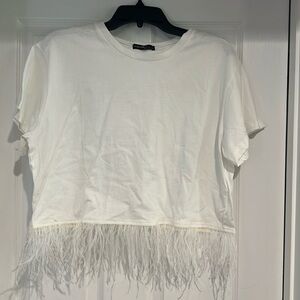 White tee shirt with feather accent at bottom of shirts